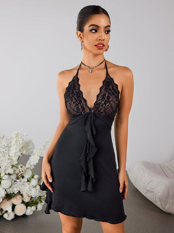 Woman wearing a black halter neck mini dress with lace bodice and ruffle details