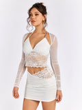 Woman posing in a white lace and mesh top with a ruched skirt.