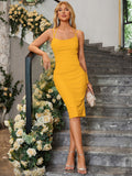 Woman leaning on a railing in a yellow ruched midi dress with side cut-outs and halter neckline, holding a clutch.