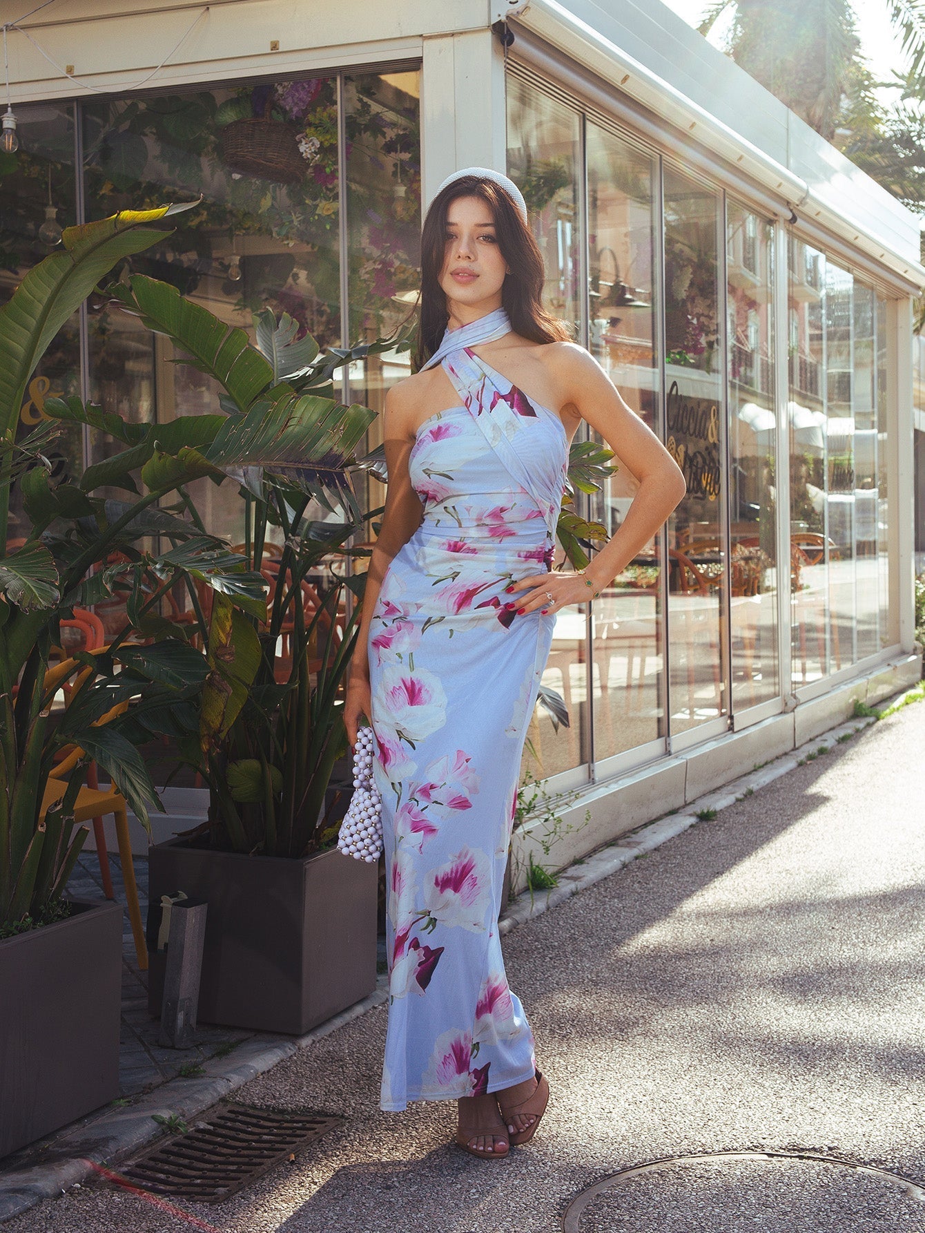 Front view of a woman modeling a light blue floral print maxi dress with a halter neckline and draped bodice.