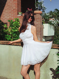 Woman in white draped dress with layered hem showing off the silhouette