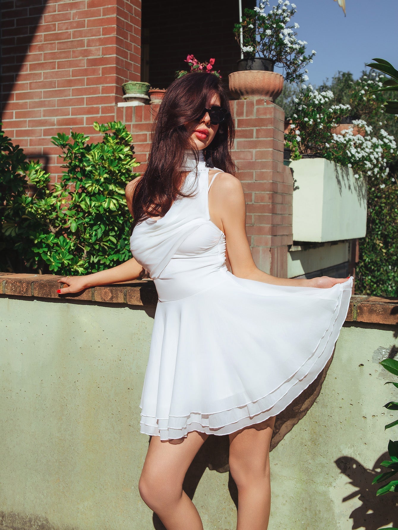 Woman in white draped dress with layered hem showing off the silhouette