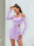 Woman smiling in a purple bodycon mini dress with halter neckline and cut-outs