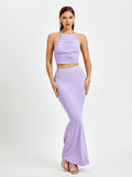 Woman wearing a lavender ruched halter crop top and a matching mermaid maxi skirt