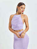 Close-up of a woman's torso in a lavender ruched halter crop top