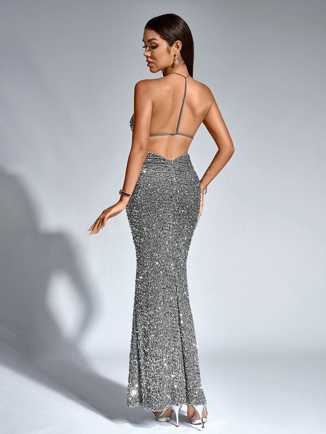 Woman wearing a shimmering silver sequined halter neck mermaid gown