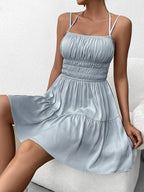 Woman sitting in a light blue tiered mini dress