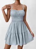 Close-up of a woman in a light blue smocked bodice mini dress