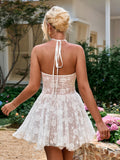 Back view of a woman in a white floral embroidered halter mini dress