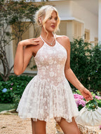 Woman posing in a white floral embroidered halter mini dress