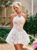 Front view of a woman in a white floral embroidered halter mini dress