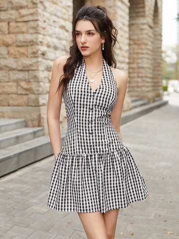 Woman wearing a black and white gingham halter neck mini dress with a tiered skirt