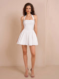 Full length view of a woman in a white halter neck fit and flare dress