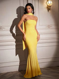 Model posing in a yellow strapless mermaid dress with a high neckline scarf.