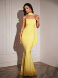 Close-up of a woman in a yellow strapless mermaid gown with a draped scarf.