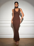 Full length view of a woman in a brown ribbed knit maxi dress featuring a plunging V-neck and halter tie