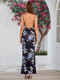 Back view of a woman in a dark floral print satin maxi dress with an open back