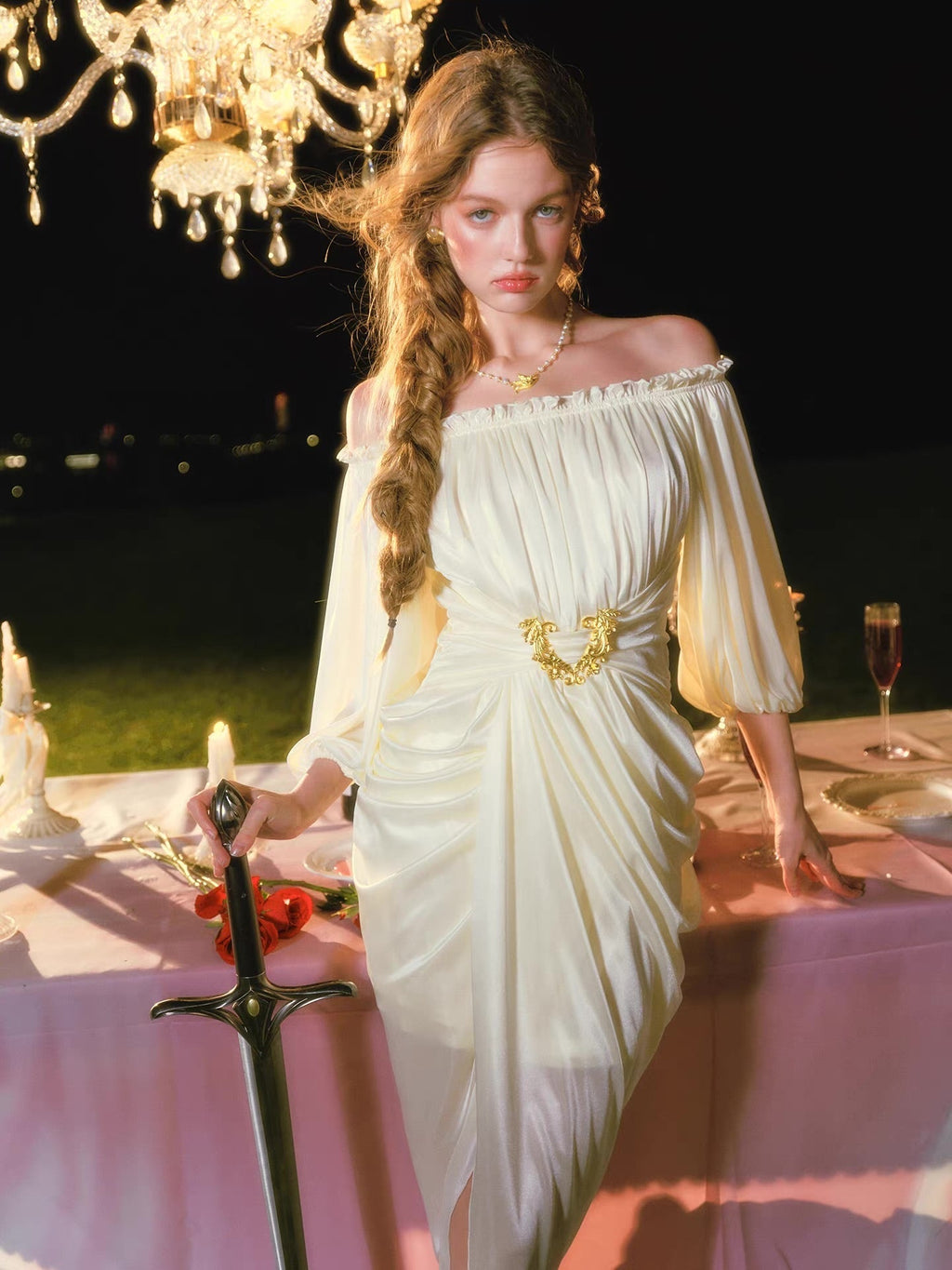 Detail of the gold belt buckle on a ruched cream satin gown.