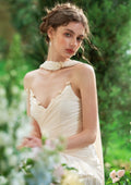 Model posing in an elegant cream silk satin gown with a sweetheart neckline and draped skirt.