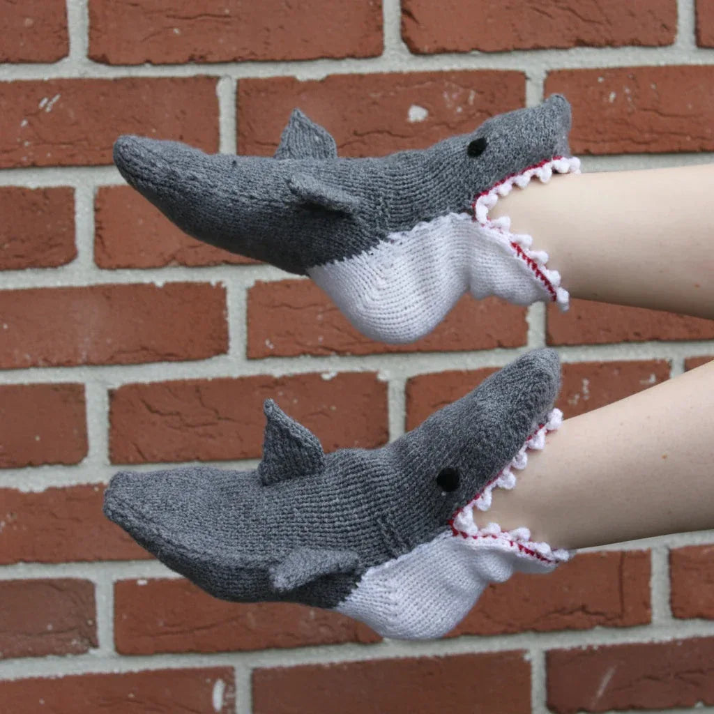 Pair of grey knitted shark-shaped gloves on arms, with white and red teeth detail