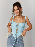 Smiling woman in a light blue jacquard lace-up camisole