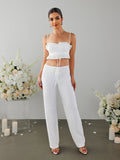 Woman wearing a white cropped top and white pants