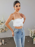 Woman posing in a white cropped top and blue jeans