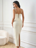 Back view of a woman in a white textured knit sheath dress featuring a lace-up back closure and a side slit.