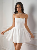 Woman wearing a white embroidered mini dress with spaghetti straps and a sweetheart neckline.