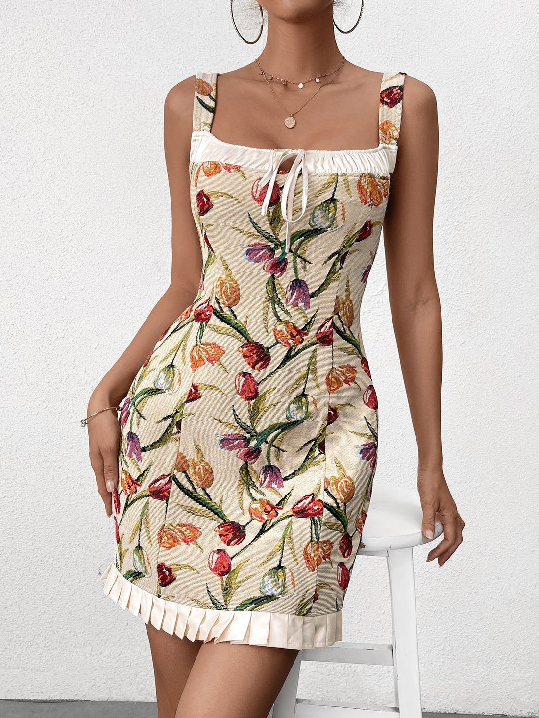 Woman wearing a sleeveless floral print bodycon dress with a square neckline and ruffled hem