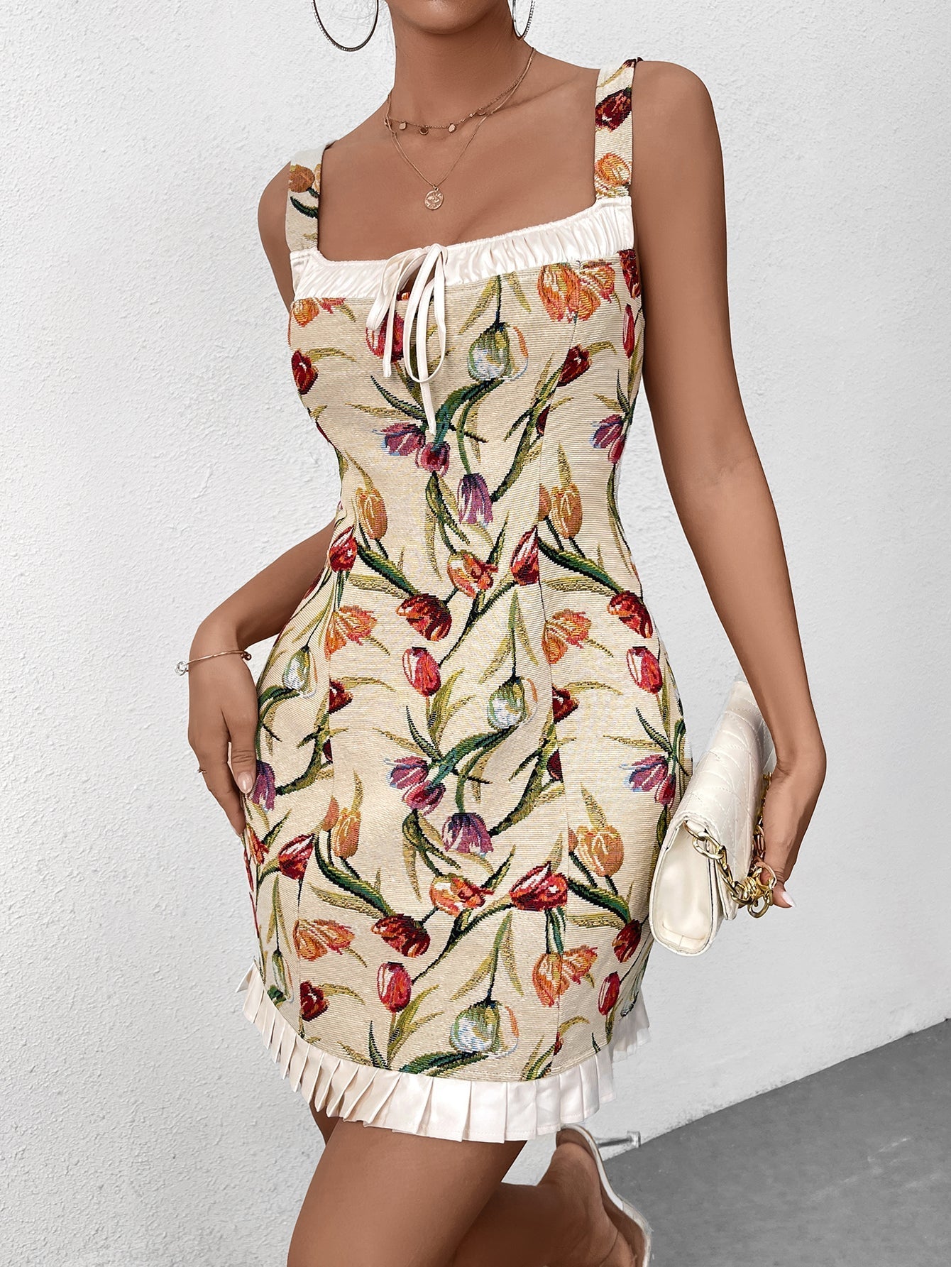 Woman in a floral print dress with a white clutch handbag