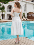 Back view of a woman in a white eyelet embroidered midi dress with a lace-up back detail, standing by a pool.
