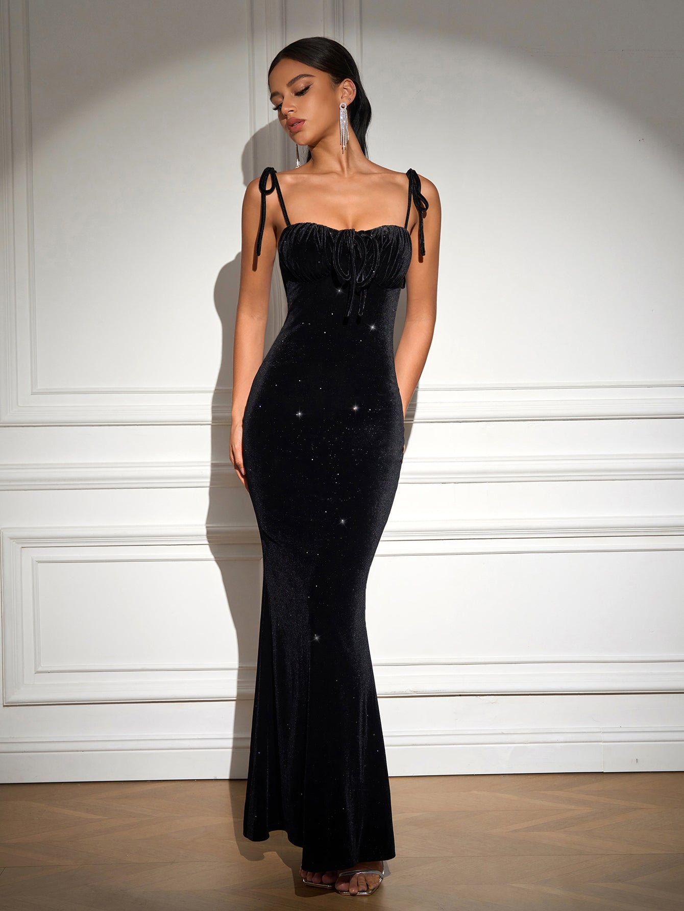 Full length black velvet mermaid gown with spaghetti straps and sparkling embellishments