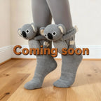 Gray knitted socks with attached plush koala characters hugging the leg