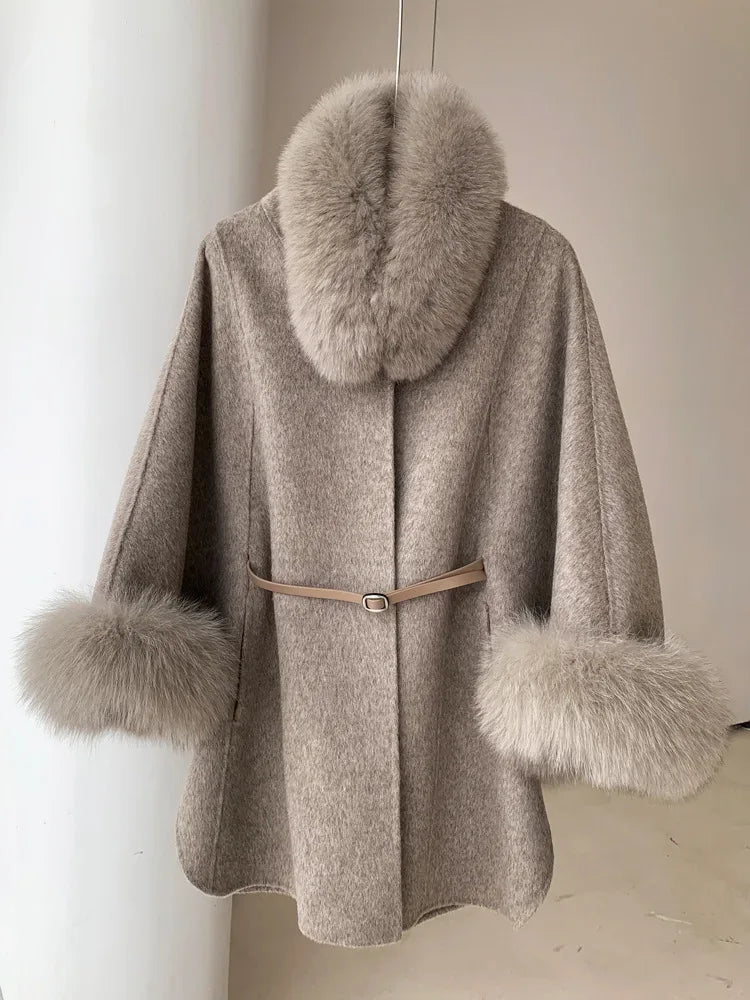 Beige wool blend cape with fur trim collar and cuffs, cinched with a belt.