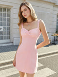 Woman posing in a pink A-line mini dress with lace accents.
