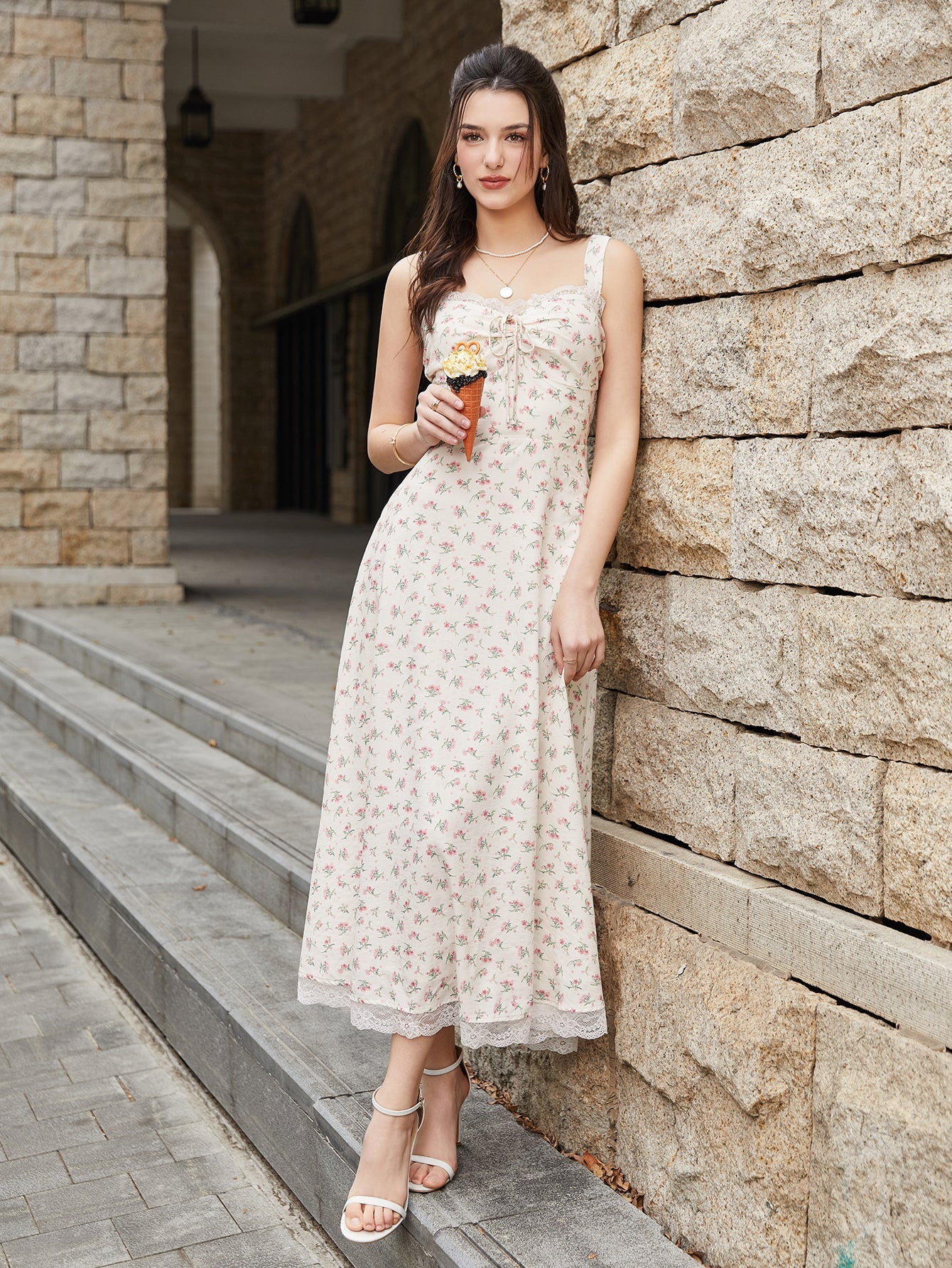 Woman holding an ice cream cone while wearing a cream floral print midi dress