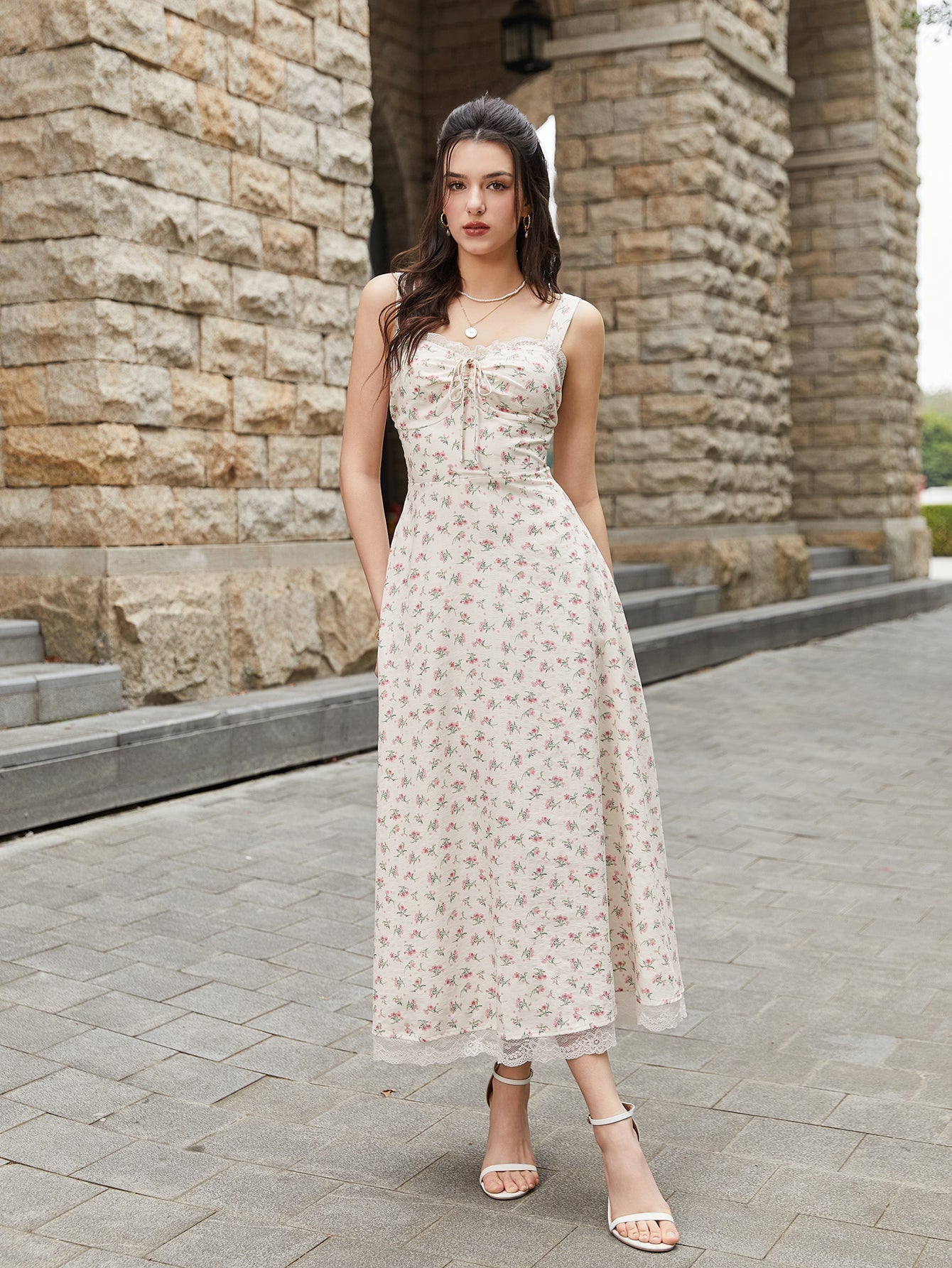 Front view of a woman modeling a cream floral print midi dress with adjustable straps