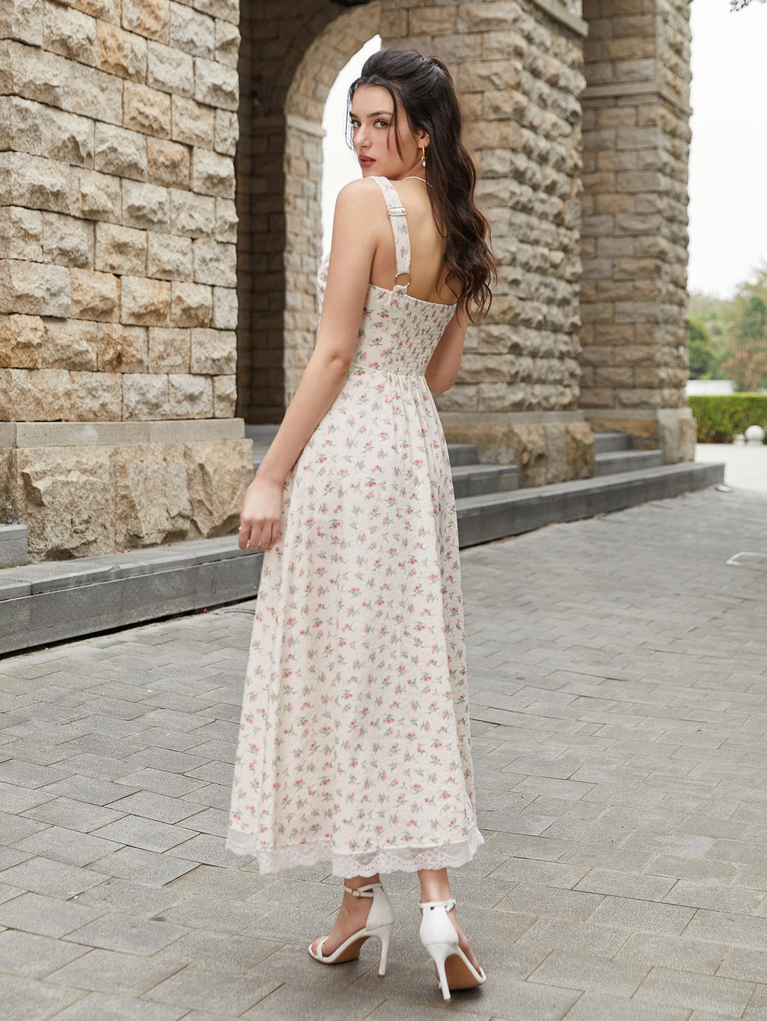 Woman wearing a cream floral print midi dress with a tie-front bodice and lace trim