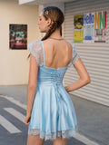Back view of a light blue satin fit and flare dress with a ruched bodice, lace trim, and lace-up back detail.