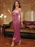 Woman in a long pink satin slip dress with one hand extended