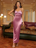 Woman posing in a long pink satin slip dress with her hand on her hip