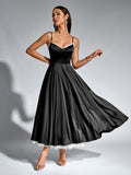 Woman in a black satin fit and flare midi dress with spaghetti straps and lace trim.