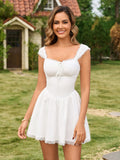 Front view of a woman smiling, wearing a white mini dress with lace trim and a square neckline.