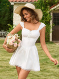 Woman holding a basket of flowers, wearing a white mini dress and a straw hat, smiling in a garden.