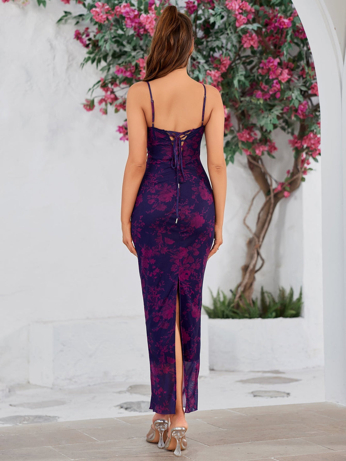 Woman wearing a purple and pink floral print maxi dress with spaghetti straps and a lace trim neckline.