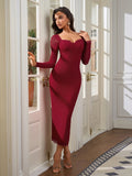 Woman in a fitted red dress with mesh sleeves and lace detail, leaning against a doorway.