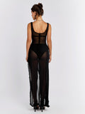 Back view of a woman in a long black sheer dress with ruffled trim