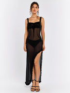 Full front view of a woman in a long black sheer dress with ruffled trim