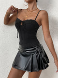 Woman posing in a black ribbed knit camisole with adjustable spaghetti straps.